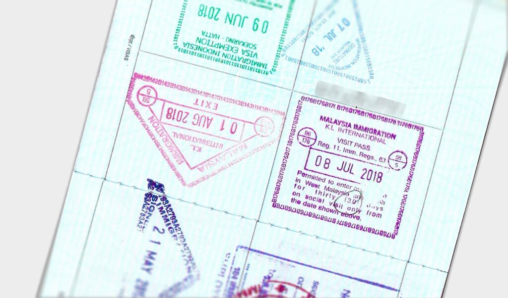 Malaysia tourist visa entry and exit stamps in the passport